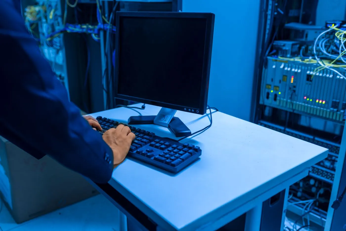 Technician at a keyboard in a server room