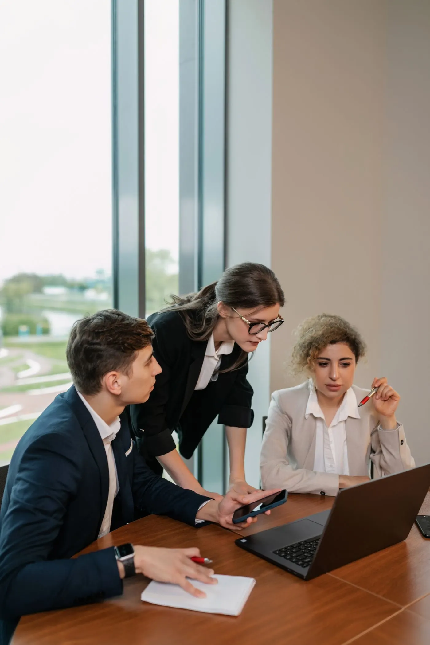 Trois personnes examinant un rapport sur un ordinateur portable